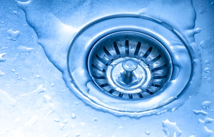 A drain with clear water. Whole picture is dominated by blue colors.