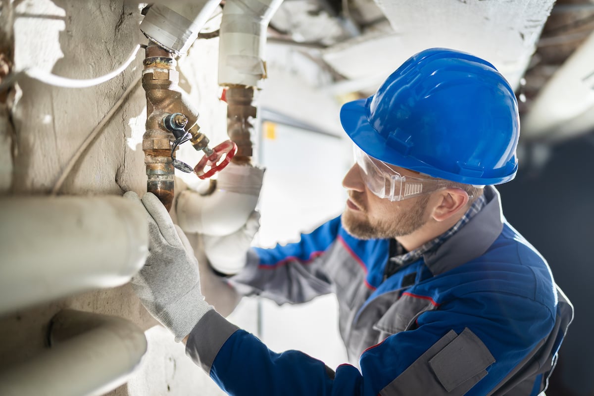 Plumber checking valve on plumbing maintenance checklist