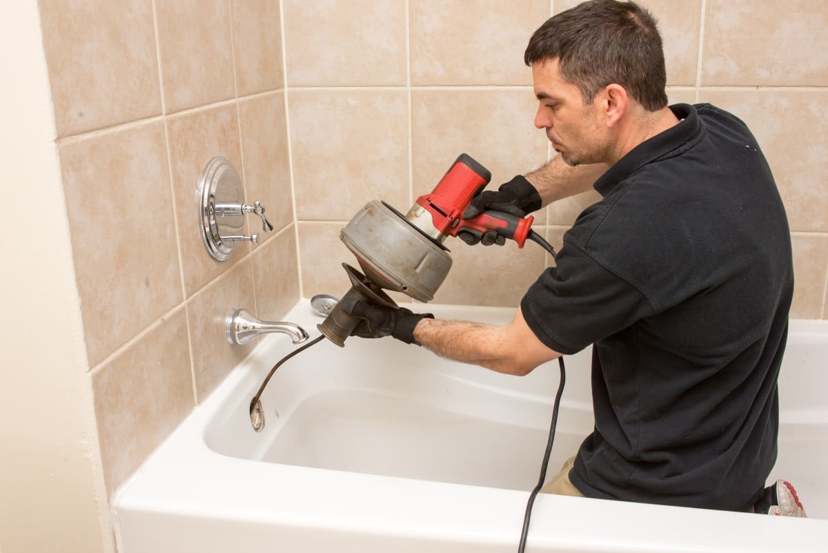 man using a drain snake